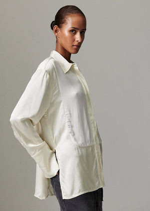 Woman wearing a white shirt against a gray background