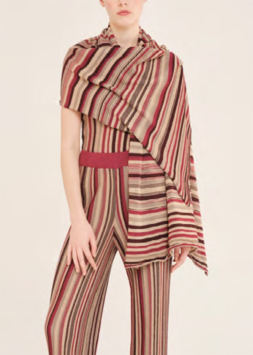 Person wearing a striped outfit with a scarf on a beige background