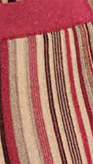 Close-up of a striped fabric with red, beige, and black colors.