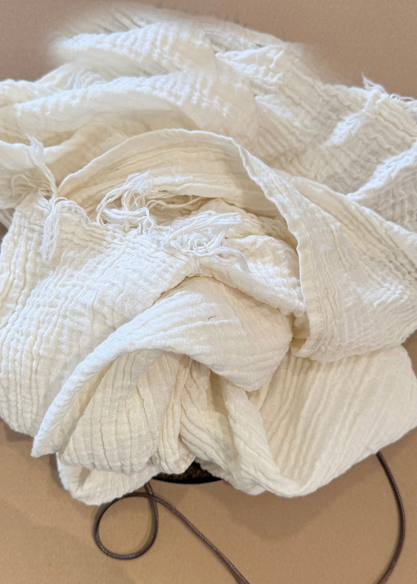 Person wearing a gray scarf with a white background