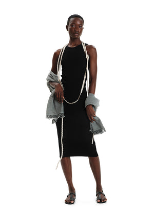 Model wearing a black dress with white trim against a white background