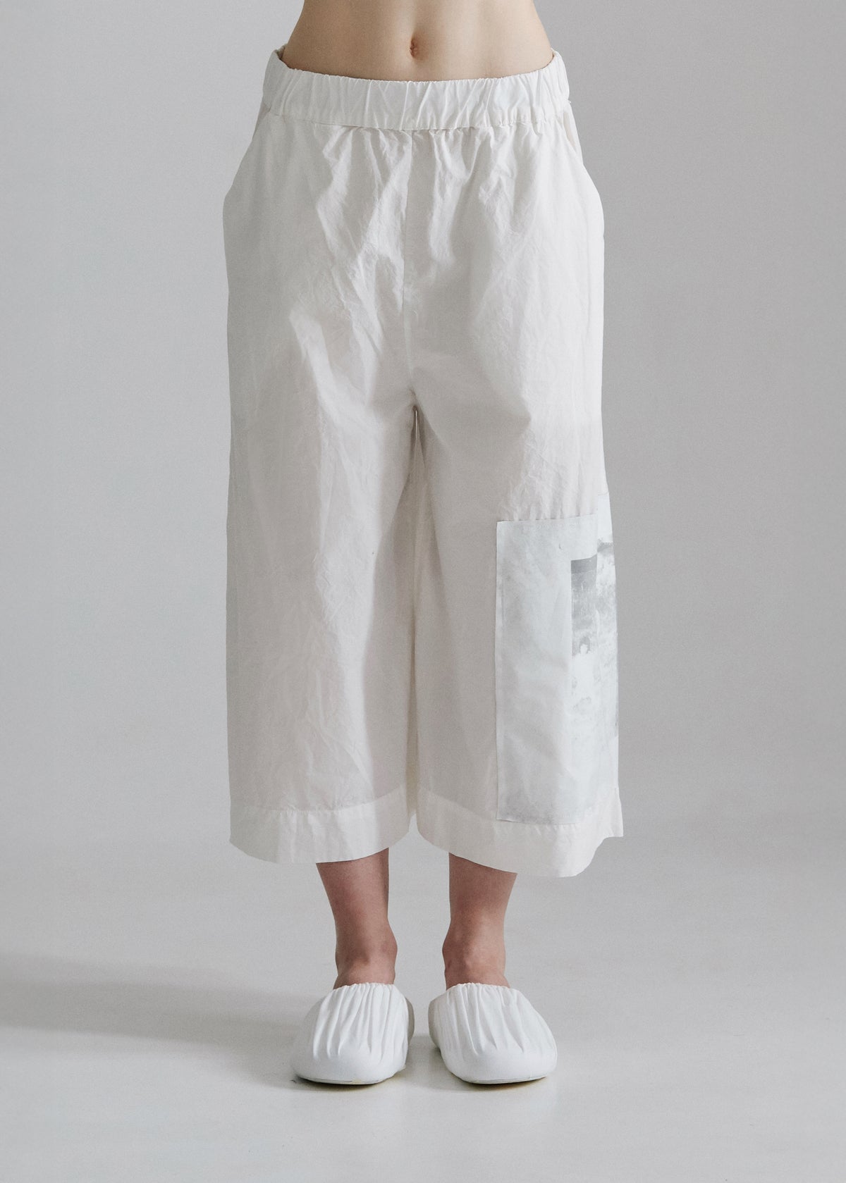 White wide-leg pants worn by a person on a plain background