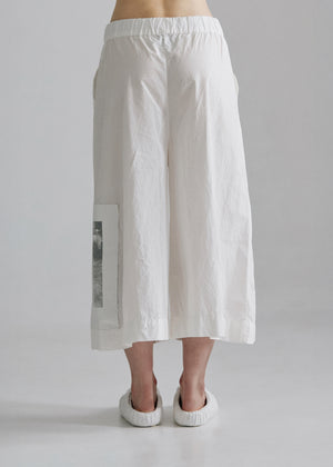 White wide-leg pants worn by a person on a plain background