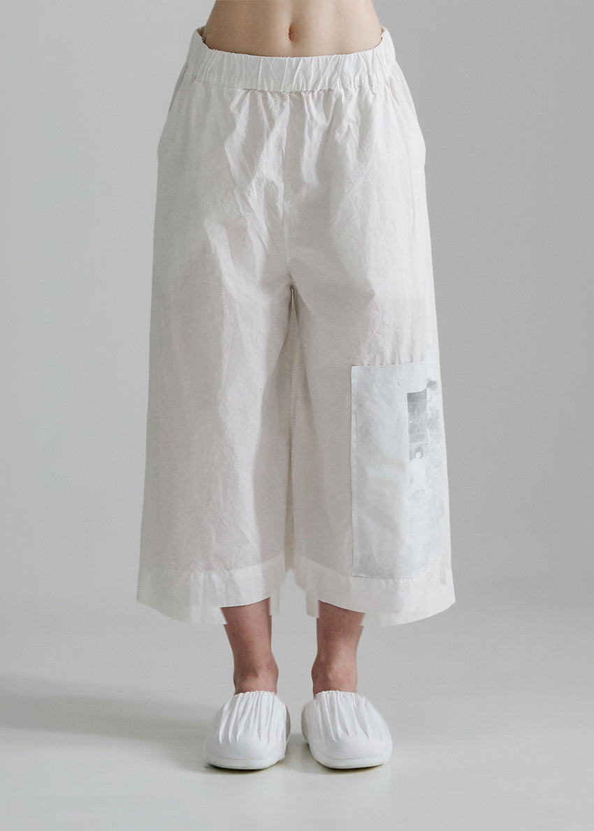 White wide-leg pants worn by a person on a plain background