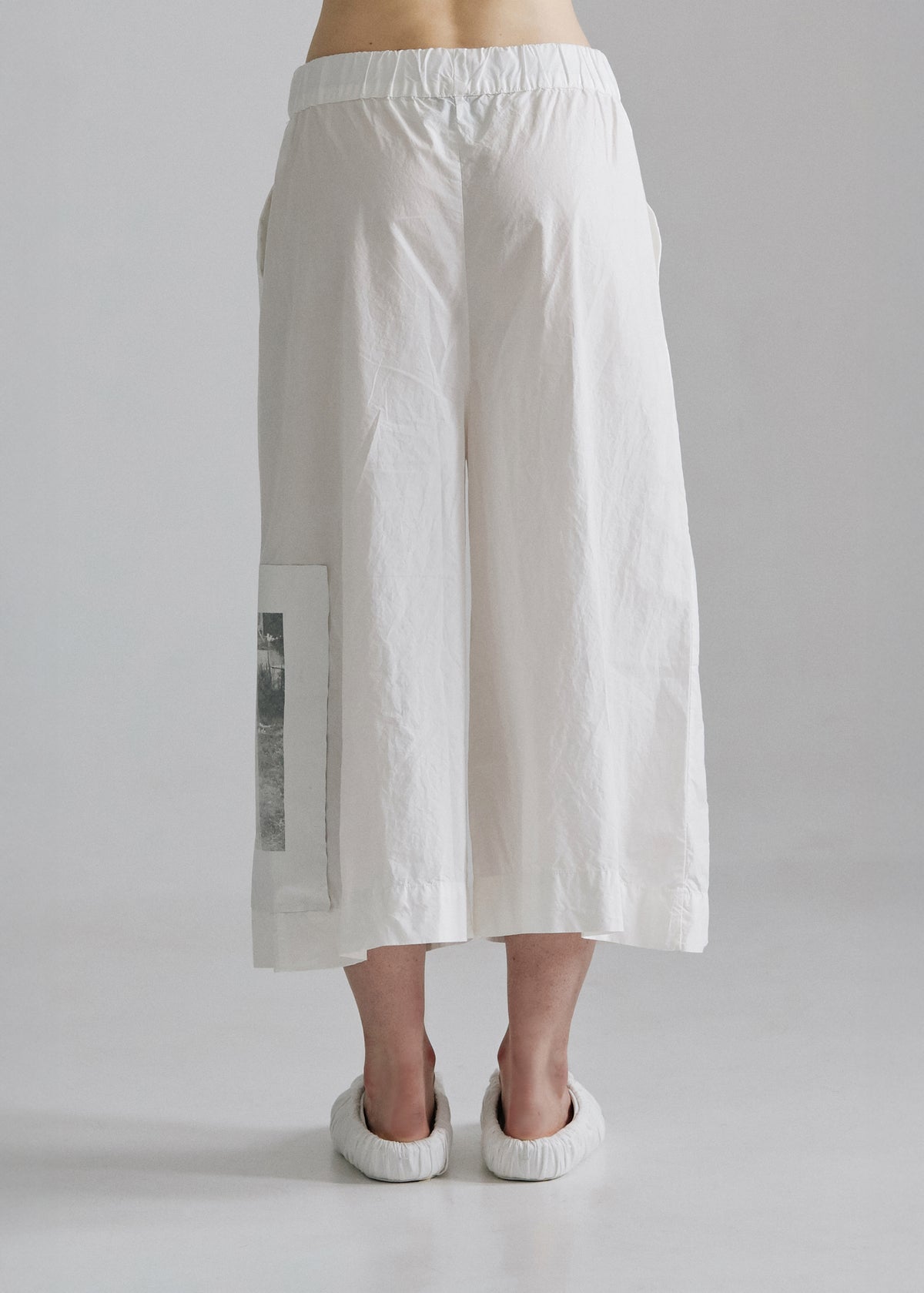 White wide-leg pants worn by a person on a plain background
