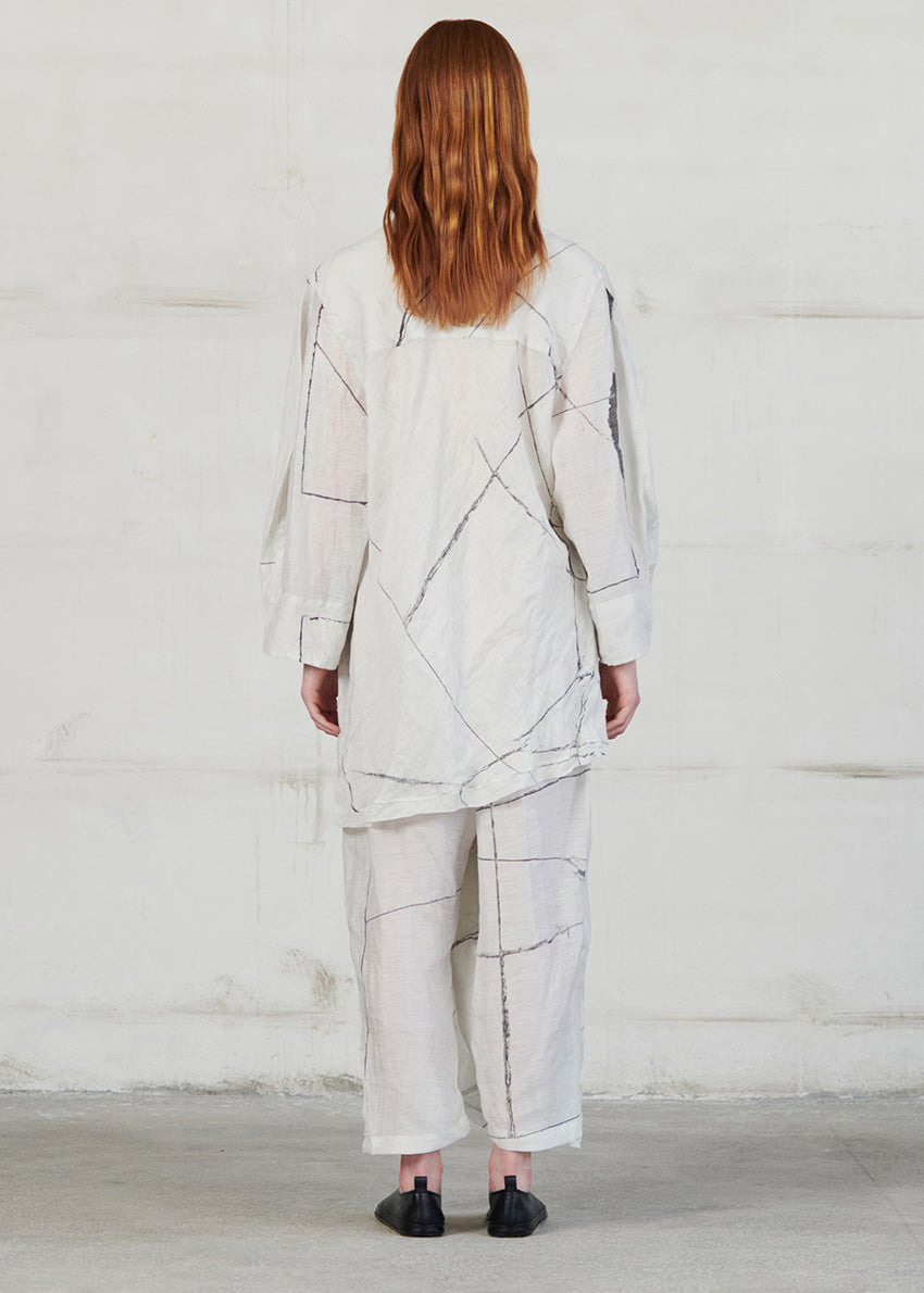 Person wearing a light gray abstract patterned outfit against a white background