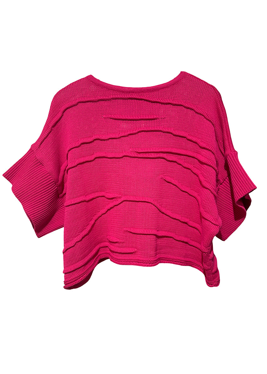 Pink layered knit poncho on a white background