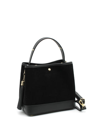 A black suede and leather handbag with a circular handle, fringe accents, and a crossbody strap.