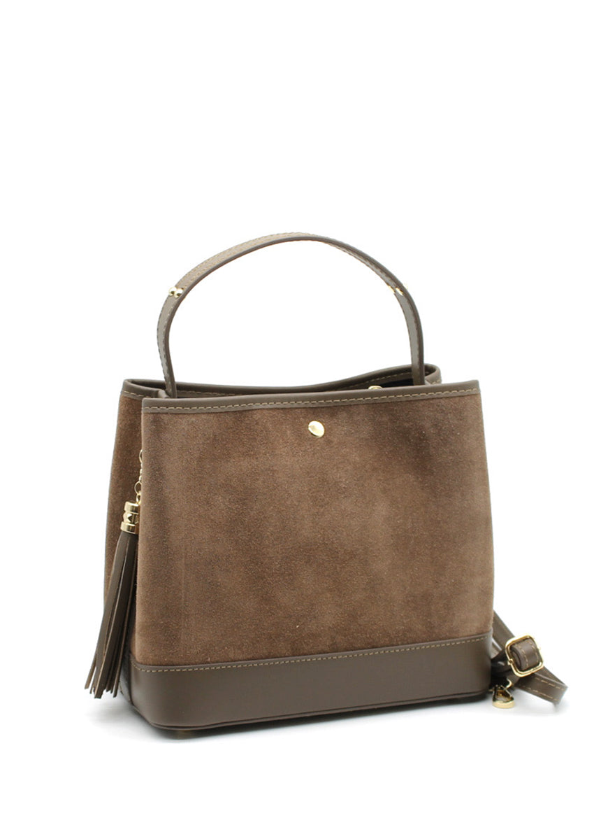 A brown suede and leather handbag with a circular handle, fringe accents, and a crossbody strap.
