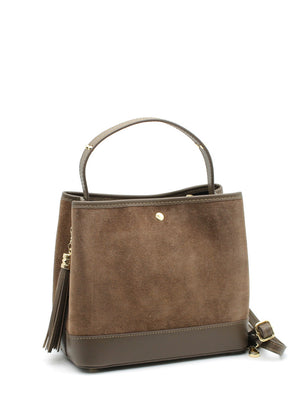 A brown suede and leather handbag with a circular handle, fringe accents, and a crossbody strap.