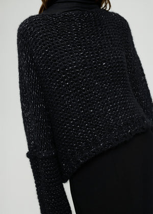 Black textured sweater on a plain background