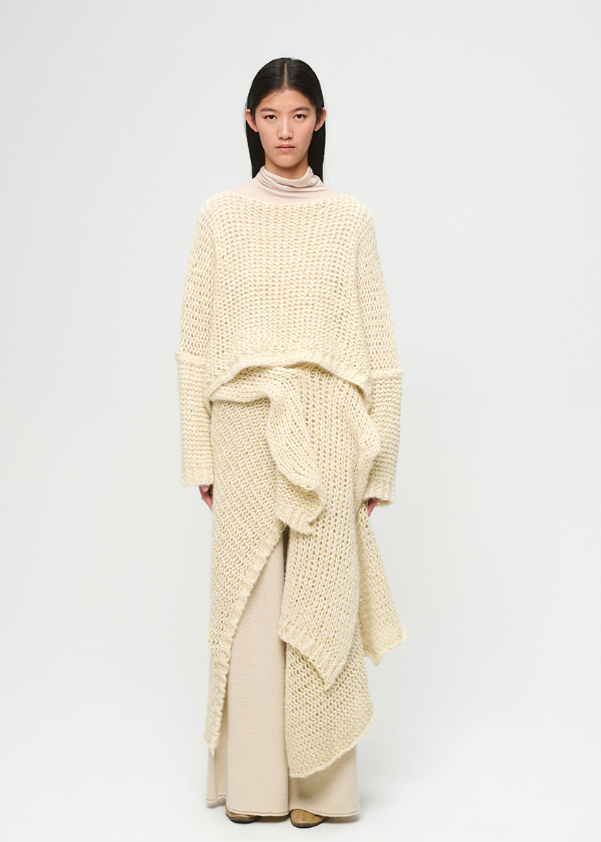 Woman wearing a cream-colored knit outfit on a white background