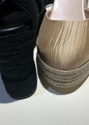 Close-up of black and beige shoes with woven details on a white background