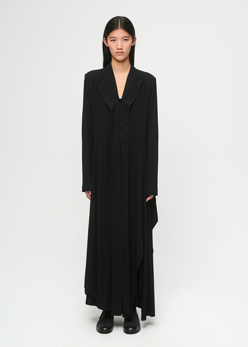 Model wearing a long black dress on a white background