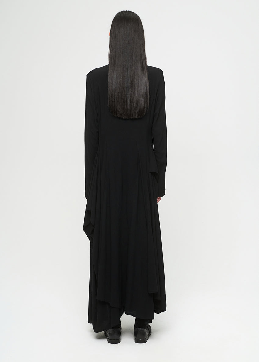 Person wearing a long black dress on a white background