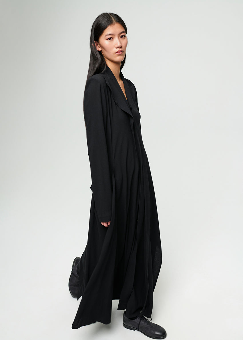 Woman wearing a long black dress against a white background