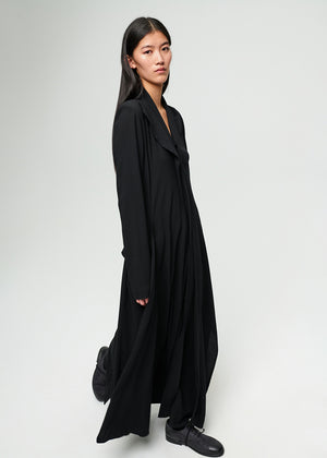 Woman wearing a long black dress against a white background