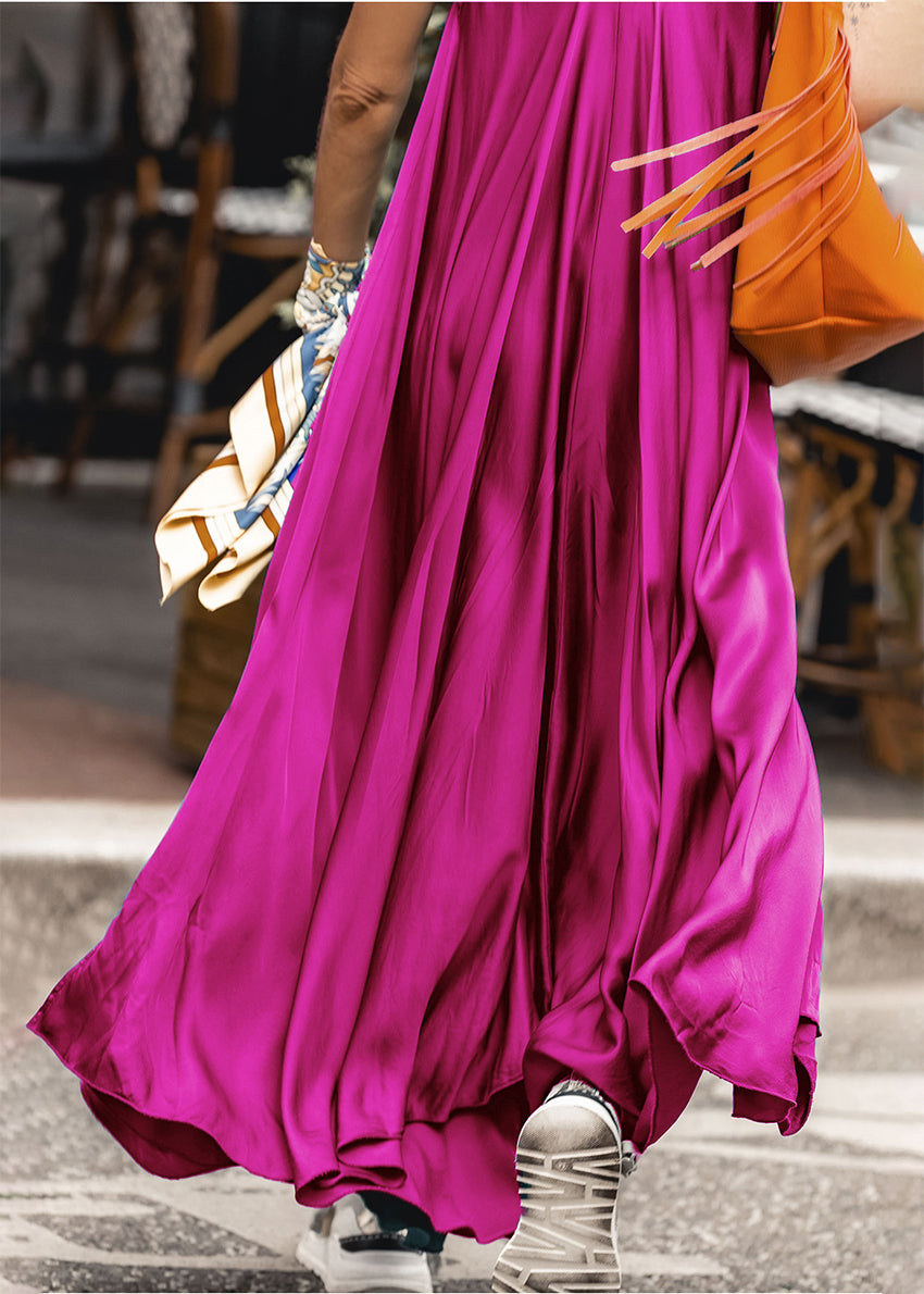 Woman wearing a medium purple silk dress with a orange bag