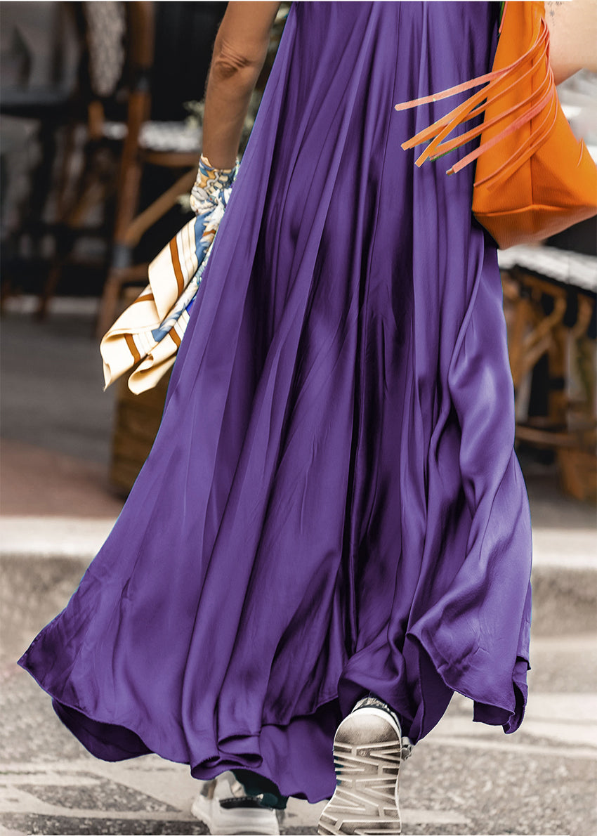 Woman wearing a purple silk dress with a orange bag