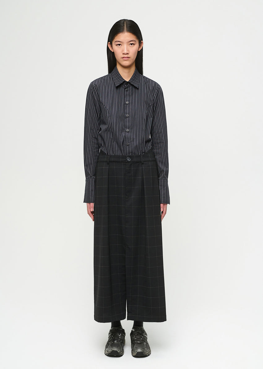 Person wearing a black and white striped shirt with skirt on a white background