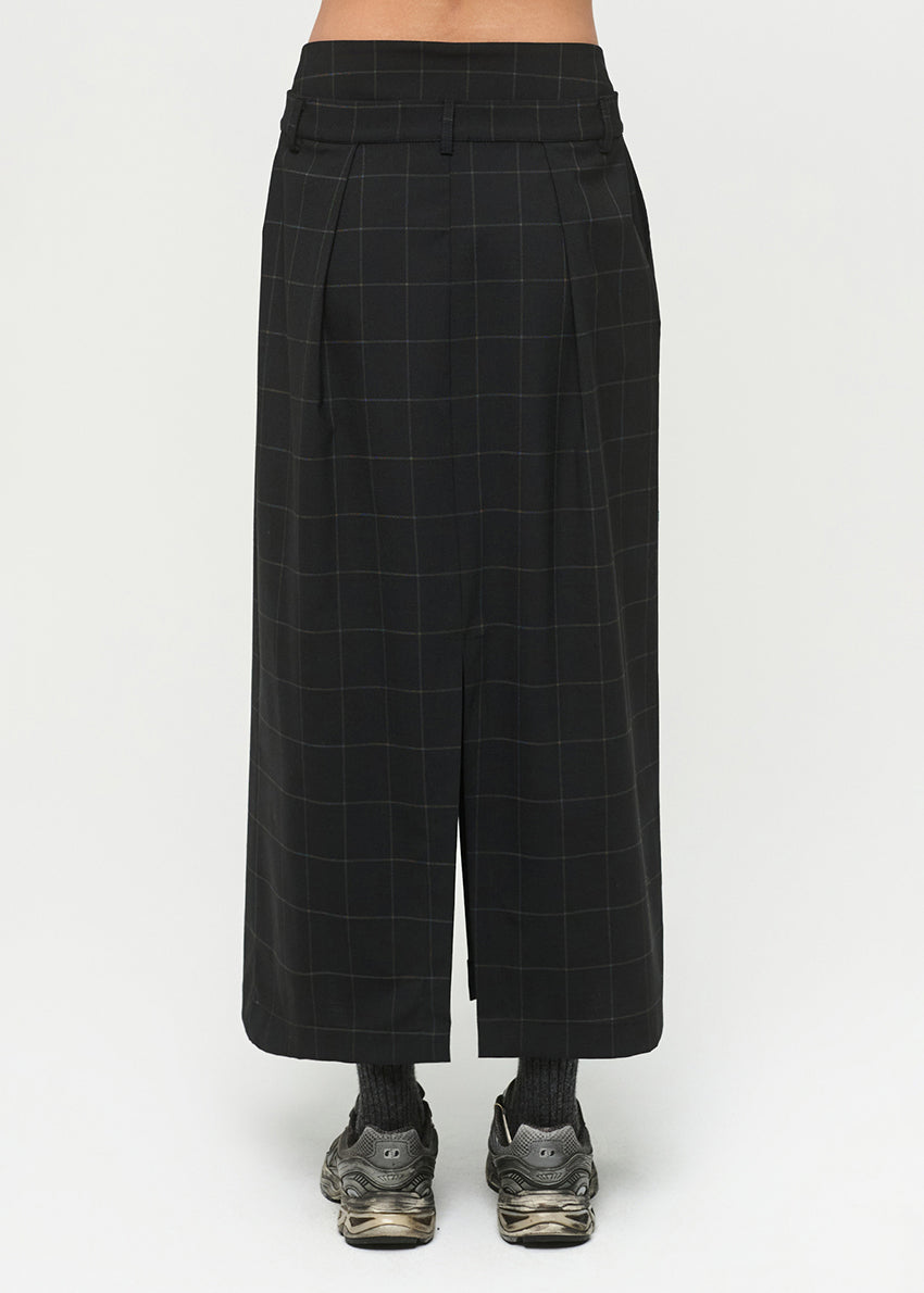 Black checkered skirt worn by a person on a white background