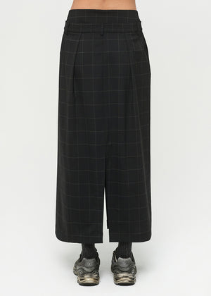 Black checkered skirt worn by a person on a white background