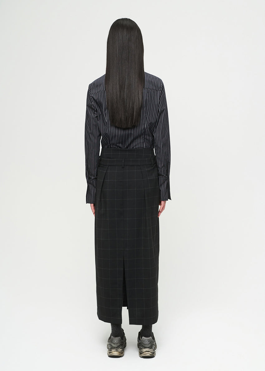 Person wearing a striped shirt and black skirt on a white background