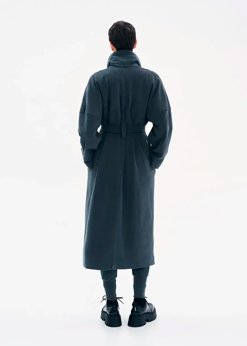 A model wearing a gray coat with a belt, featuring a buttoned front and a flowing fit.