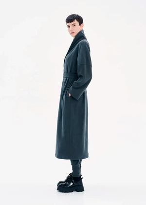 A model wearing a gray coat with a belt, featuring a buttoned front and a flowing fit.
