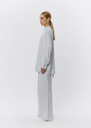 Woman wearing a light gray outfit on a white background
