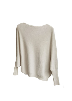 A beige, asymmetrical hemline sweater with fitted sleeves that flare out into a poncho-like shape