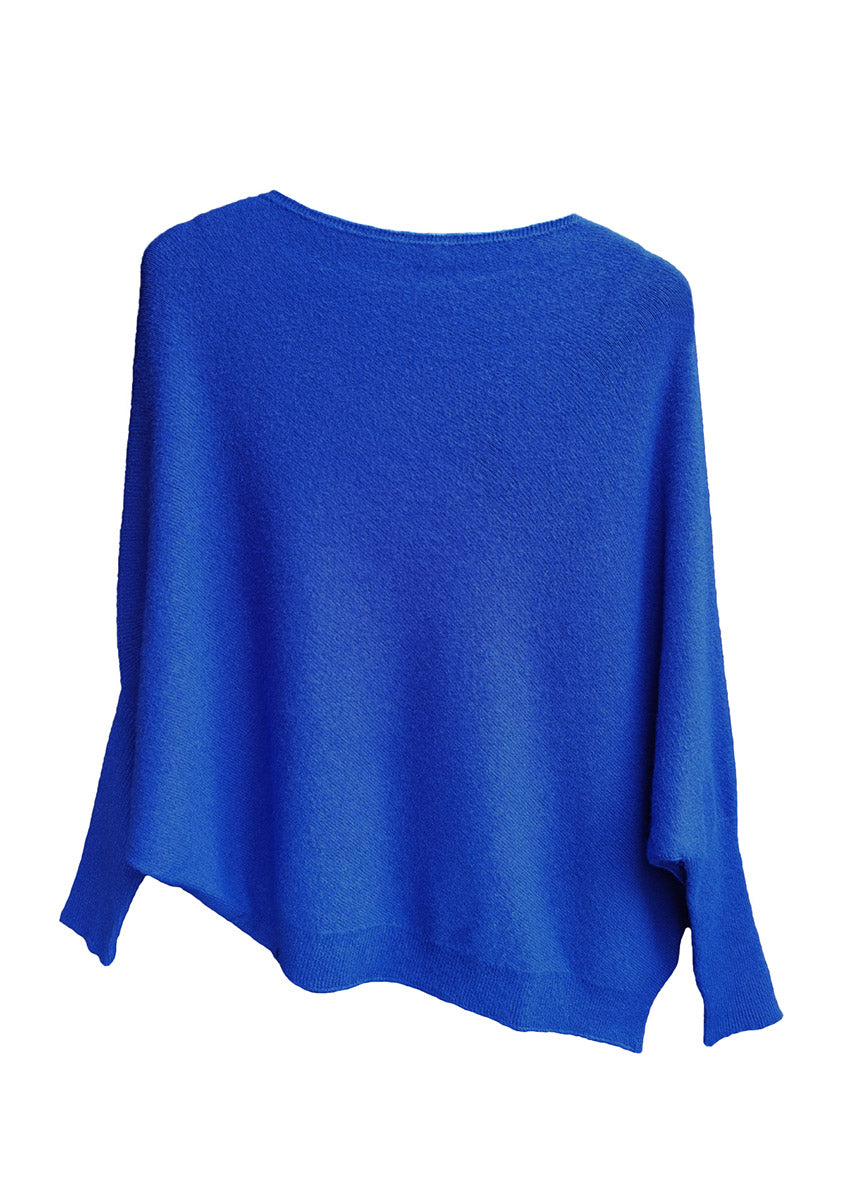 A blue, asymmetrical hemline sweater with fitted sleeves that flare out into a poncho-like shape