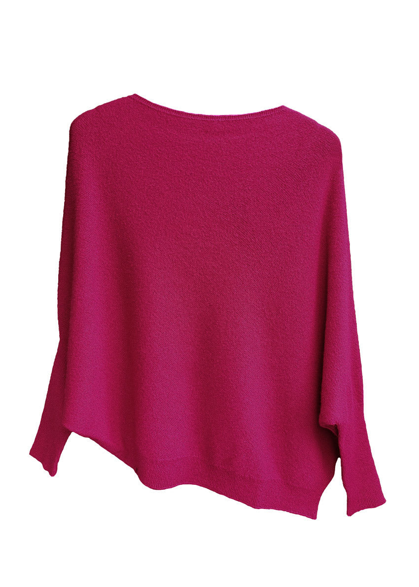 A fire brick, asymmetrical hemline sweater with fitted sleeves that flare out into a poncho-like shape
