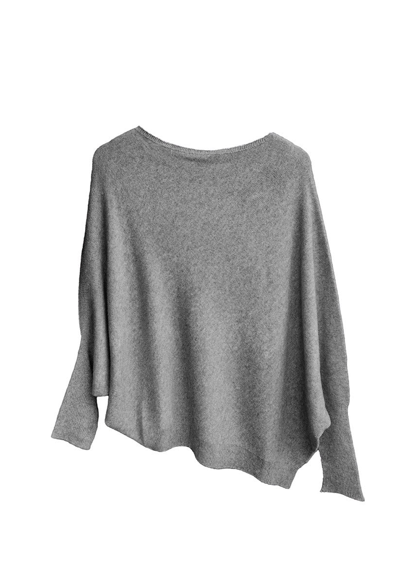 A grey, asymmetrical hemline sweater with fitted sleeves that flare out into a poncho-like shape