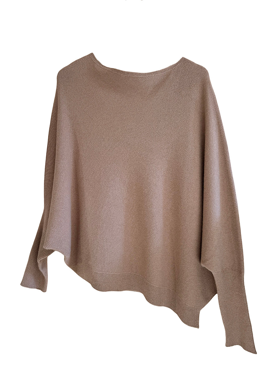 A peru, asymmetrical hemline sweater with fitted sleeves that flare out into a poncho-like shape