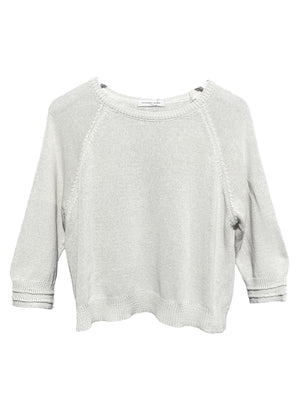 White short sweater with 3/4 sleeves and decorative stitching on the sleeves laid flat.