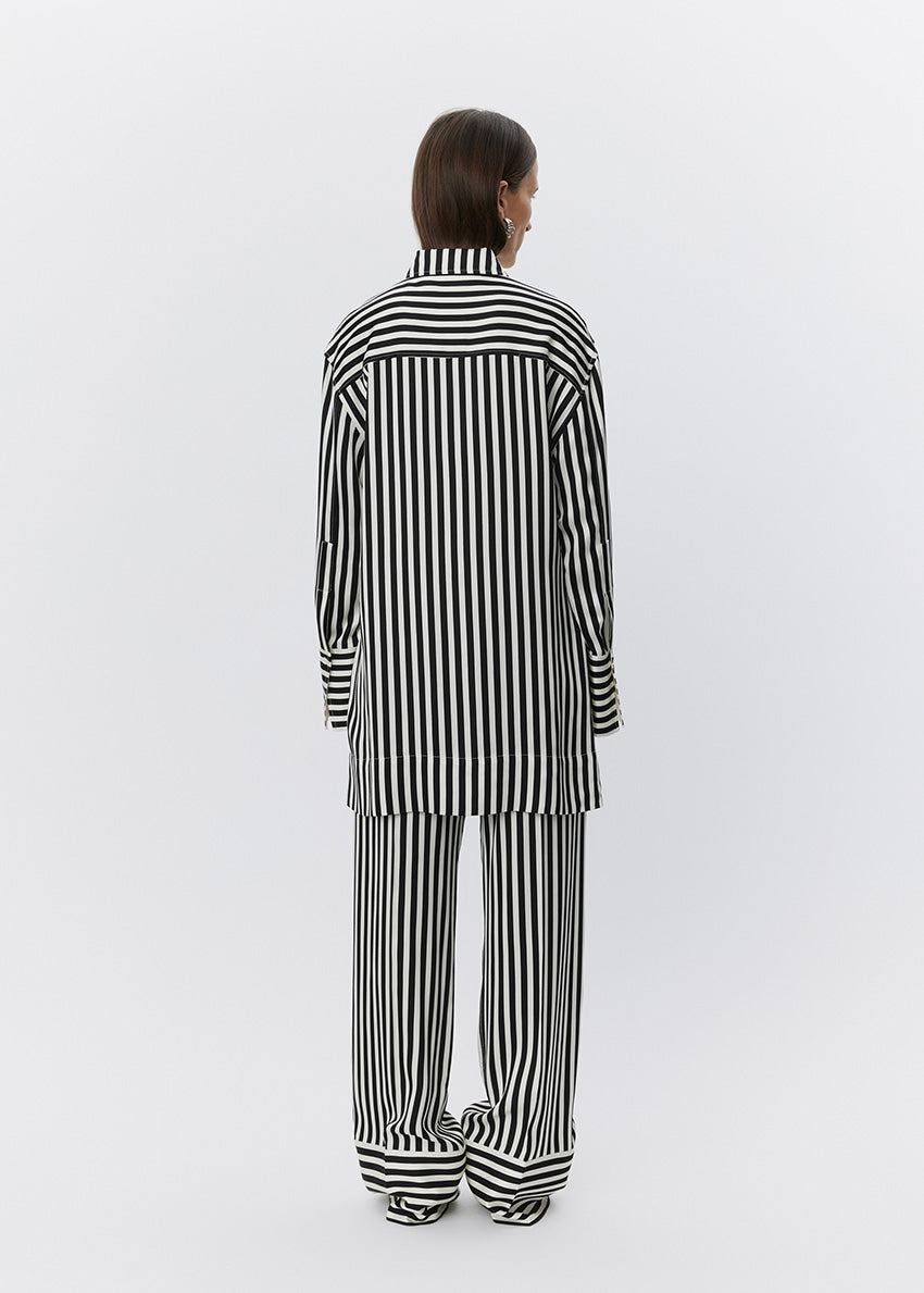 Person wearing a black and white striped outfit on a white background