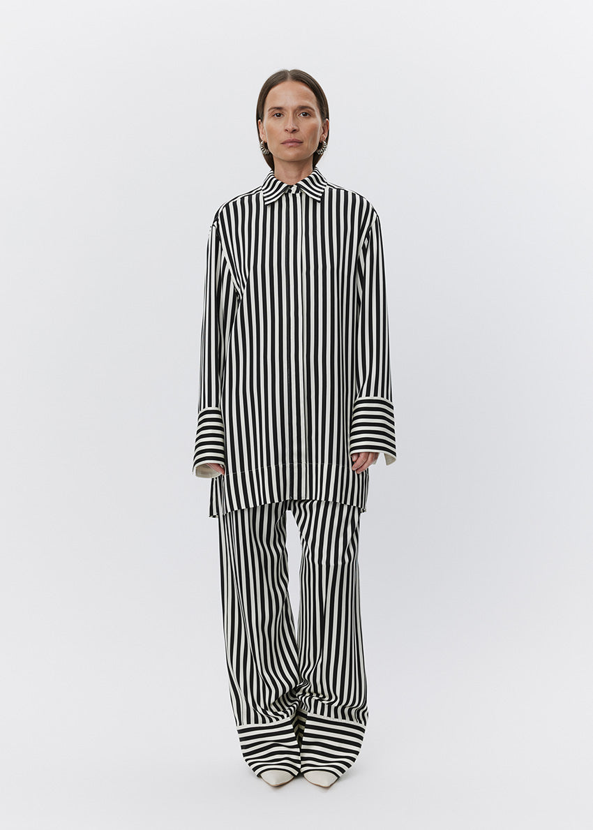 Person wearing a black and white striped outfit on a white background