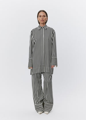 Person wearing a black and white striped outfit on a white background
