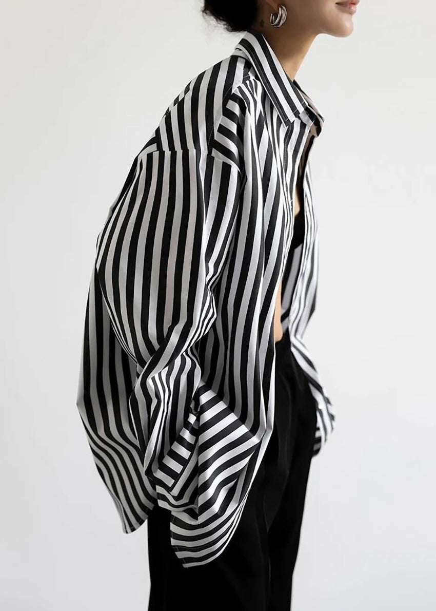 Person wearing a black and white striped shirt against a plain background