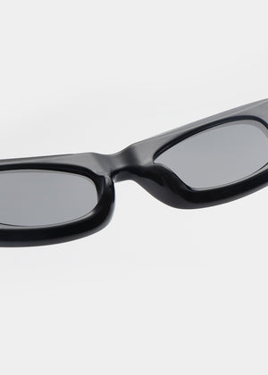 Black sunglasses with gray lenses on a light gray background