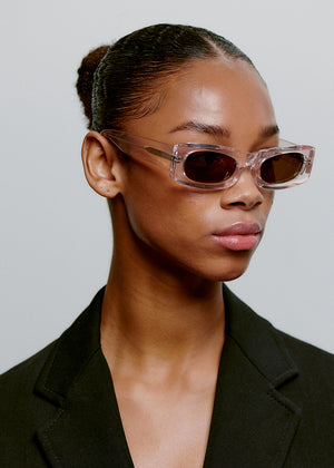 Person wearing clear sunglasses with a neutral background