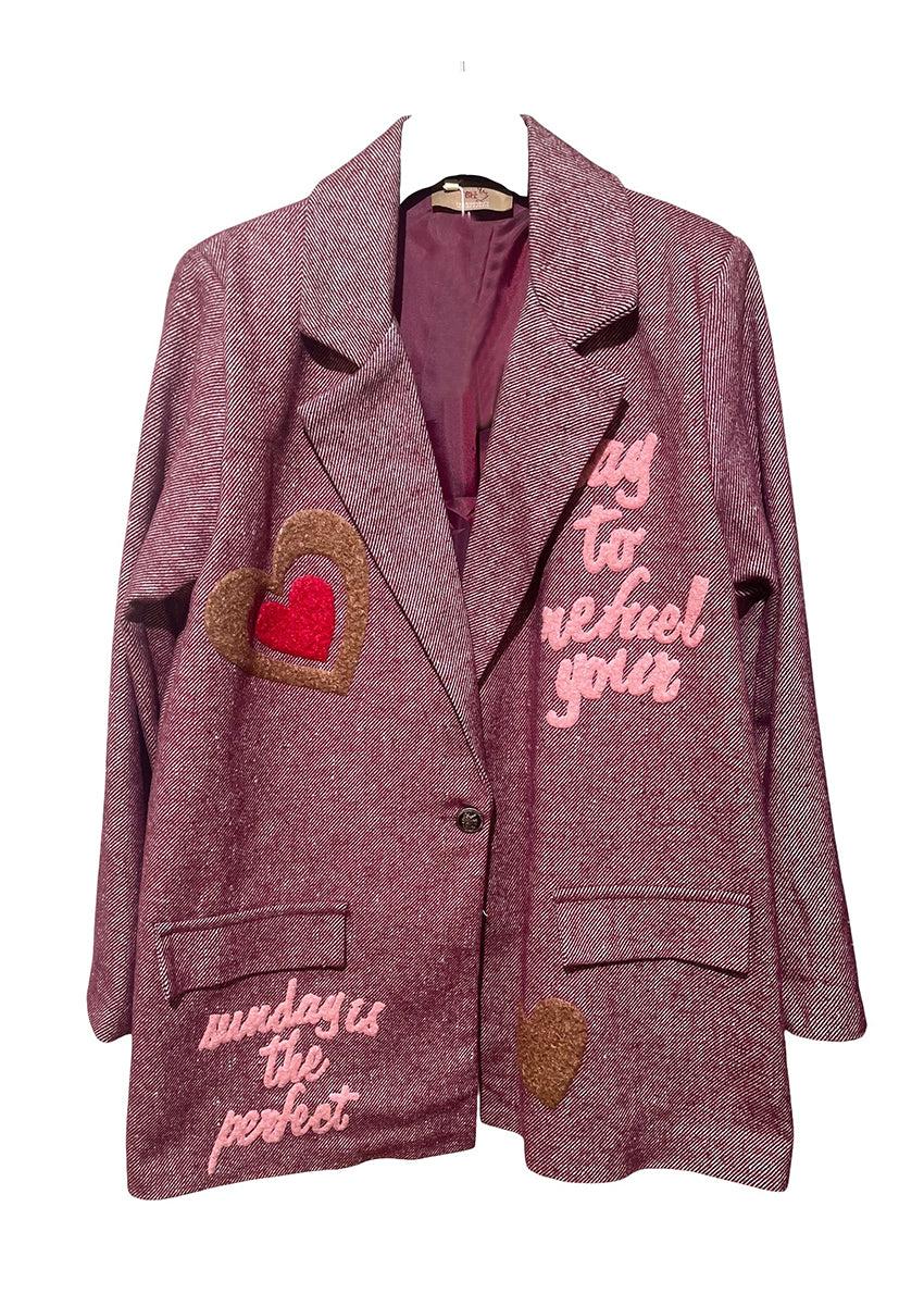 Pink blazer with heart designs and text on a white background