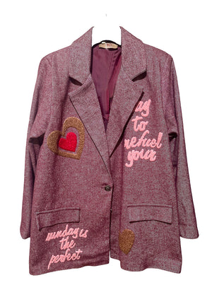 Pink blazer with heart designs and text on a white background