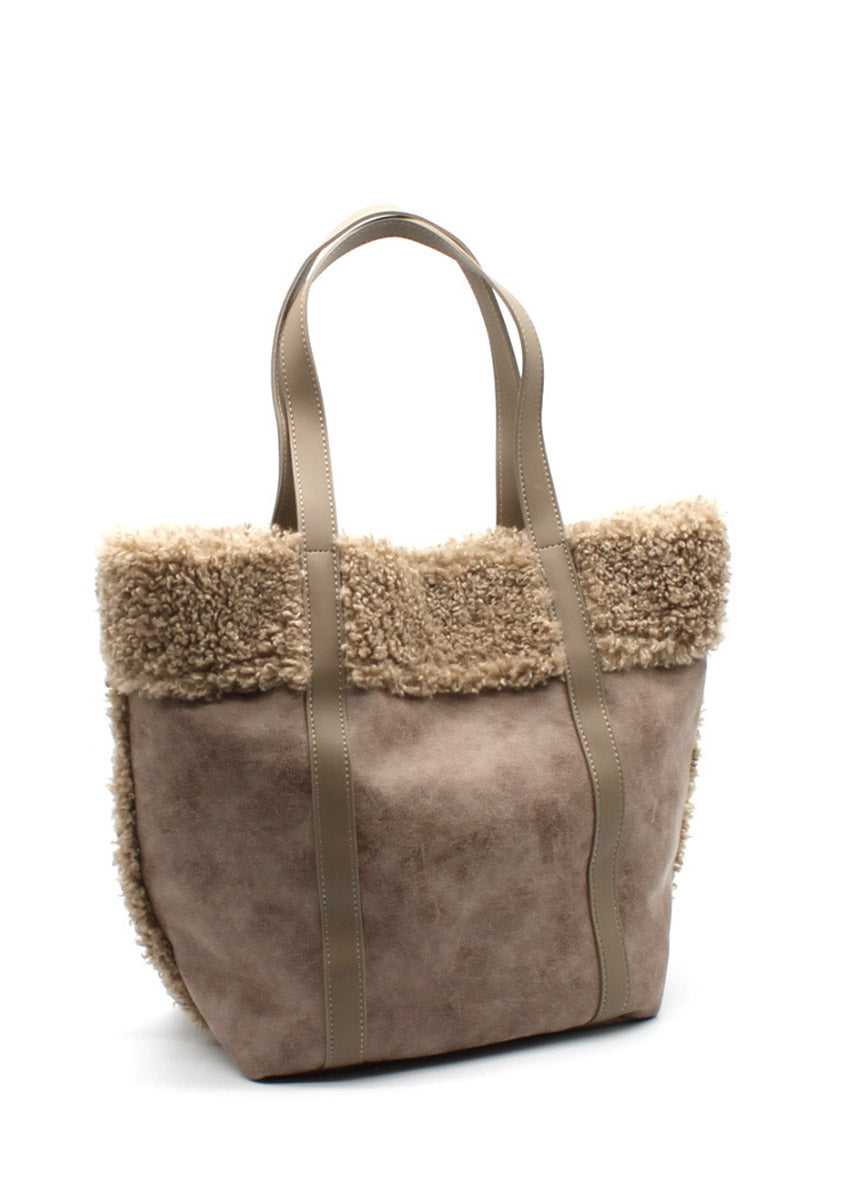 A beige suede tote bag with faux shearling trim, sturdy handles, and a spacious design.
