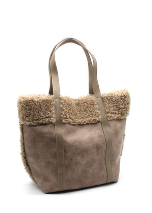 A beige suede tote bag with faux shearling trim, sturdy handles, and a spacious design.