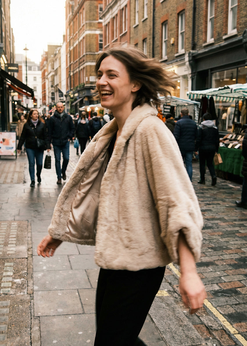 Woman walking on a city street with brick buildings and people in the background