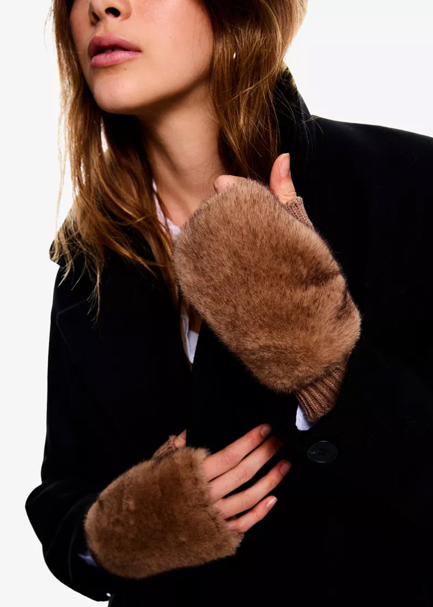 Person wearing brown fur-lined gloves with a plain background