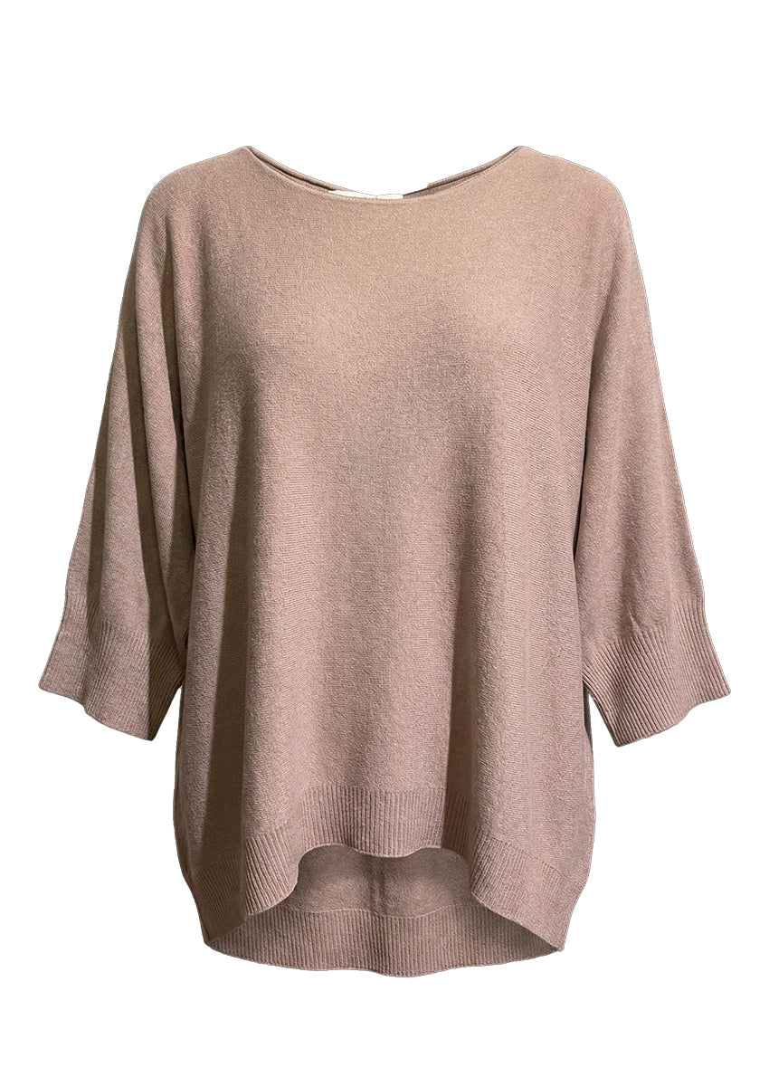 Woman wearing a tan sweater and sunglasses on a white background