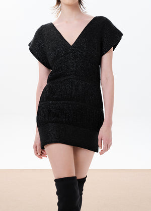 A sleeveless, cap-shouldered, viscose yarn with metallic threads cocktail dress with fringed detailing and elastic tulle lining, paired with black boots.